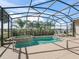 Relaxing screened pool with a jacuzzi, lounge furniture, and views of the golf course at 12136 Se 176Th Loop, Summerfield, FL 34491