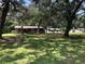 Well-maintained front yard with lush green grass, mature trees, and a charming single story house at 136 S Commercial St, Coleman, FL 33521