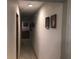 Hallway leading to other rooms with framed photos decorating the white walls at 136 S Commercial St, Coleman, FL 33521