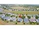 Expansive aerial view of a community highlighting many homes with solar panels and a large grassy common area at 142 Bayou Bend Rd, Groveland, FL 34736