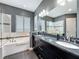 Bathroom with a double vanity, soaking tub, and frameless glass shower at 142 Bayou Bend Rd, Groveland, FL 34736