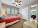 Bedroom featuring a ceiling fan, closet and bright windows with modern shutters, and adjoining bath at 142 Bayou Bend Rd, Groveland, FL 34736