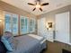 Cozy bedroom with neutral tones, plantation shutters, ceiling fan, dresser, and carpeted floor at 142 Bayou Bend Rd, Groveland, FL 34736