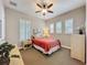 Bedroom featuring a ceiling fan, bright windows with modern shutters, and neutral color palette at 142 Bayou Bend Rd, Groveland, FL 34736
