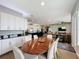 Open-concept dining area featuring an oval table, seating for six, and views into the modern kitchen and living spaces at 142 Bayou Bend Rd, Groveland, FL 34736