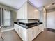 Kitchenette featuring ample white cabinetry, black countertops, modern appliances, and convenient access to the hallway at 142 Bayou Bend Rd, Groveland, FL 34736