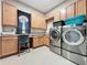 Well-equipped laundry room with modern washer and dryer, ample counter space, and custom cabinetry at 142 Bayou Bend Rd, Groveland, FL 34736