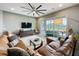 Bright living room with large sectional sofa, statement ceiling fan and screened-in patio access at 142 Bayou Bend Rd, Groveland, FL 34736