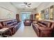 Bright living room with tile flooring, leather sofas, decor, and screened-in patio access at 142 Bayou Bend Rd, Groveland, FL 34736