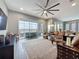 Spacious living room with plush leather seating, ceiling fan, and sliding glass doors at 142 Bayou Bend Rd, Groveland, FL 34736