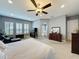 Spacious primary bedroom suite with an ensuite bathroom, comfortable seating, and a ceiling fan at 142 Bayou Bend Rd, Groveland, FL 34736