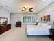 Spacious main bedroom features neutral tones, ceiling fan, and bright windows with modern shutters at 142 Bayou Bend Rd, Groveland, FL 34736