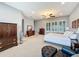 Spacious main bedroom with neutral decor, plantation shutters, ceiling fan, and a sitting area at 142 Bayou Bend Rd, Groveland, FL 34736