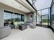 Relaxing screened-in patio featuring a fire pit table, plush seating, and tranquil views at 142 Bayou Bend Rd, Groveland, FL 34736