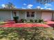 Charming single-story home with blue shutters, a red painted drive and well-kept landscaping at 15159 Sw 43Rd Terrace Rd, Ocala, FL 34473