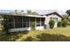 Rear view of the home featuring an enclosed back porch, landscaping, and an air conditioner at 15159 Sw 43Rd Terrace Rd, Ocala, FL 34473