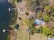 Aerial view of the home with dock and large lot surrounded by trees near lake at 1617 Lake Nettie Ct, Eustis, FL 32726