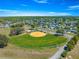 Aerial view of neighborhood baseball field and green lawns on a bright sunny day at 17594 Se 95Th Cir, Summerfield, FL 34491