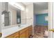 Bathroom vanity with wood cabinets, leading to a blue accent wall bedroom at 17594 Se 95Th Cir, Summerfield, FL 34491