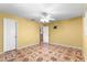 Yellow bedroom with tile floors, a ceiling fan, and TV mount, offering a bright and cozy space at 17594 Se 95Th Cir, Summerfield, FL 34491