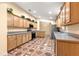 Open kitchen with wood cabinets, modern appliances, and unique tile flooring at 17594 Se 95Th Cir, Summerfield, FL 34491