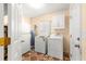 Bright laundry room with washer, dryer, storage cabinets and decorative patterned tile flooring at 17594 Se 95Th Cir, Summerfield, FL 34491
