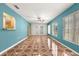 Bright living room with teal accent wall and decorative tile flooring at 17594 Se 95Th Cir, Summerfield, FL 34491