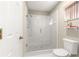 Bathroom with a frameless glass shower and white tiled walls at 17594 Se 95Th Cir, Summerfield, FL 34491