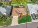 Aerial view showcasing a well-maintained home with manicured lawn, colorful flowerbeds, and a long driveway at 17898 Se 125Th Cir, Summerfield, FL 34491