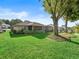 This spacious backyard features lush green grass, meticulously maintained landscaping, and a serene screened lanai at 17898 Se 125Th Cir, Summerfield, FL 34491