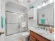 Bathroom with a tub and shower, marble vanity and tile flooring at 17898 Se 125Th Cir, Summerfield, FL 34491