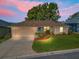 Inviting single-story home with charming curb appeal, landscaped garden, and a spacious driveway; dusk view at 17898 Se 125Th Cir, Summerfield, FL 34491