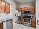 Kitchen featuring stainless steel appliances, beautiful countertops, wooden cabinets, and a view to the dining area at 17898 Se 125Th Cir, Summerfield, FL 34491