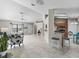 Open-concept living area with tile floors, kitchen with breakfast bar and barstools, plus living room with ceiling fan and front door at 17898 Se 125Th Cir, Summerfield, FL 34491