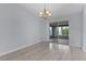 Dining room with sliding glass doors to screened patio, light gray flooring, and a modern chandelier at 17965 Se 107Th Ct, Summerfield, FL 34491