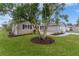 Landscaped front yard with a mature tree and well-maintained lawn at 17965 Se 107Th Ct, Summerfield, FL 34491