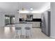 Modern kitchen with stainless steel appliances, center island with zebra-striped stools, and backyard views at 17965 Se 107Th Ct, Summerfield, FL 34491
