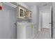 Clean laundry room featuring modern appliances, storage cabinets, and tile flooring at 17965 Se 107Th Ct, Summerfield, FL 34491