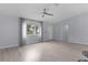 Bright living room with wood floors, a ceiling fan, and large window at 17965 Se 107Th Ct, Summerfield, FL 34491