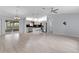 Spacious open-concept living area featuring light gray floors, views to the kitchen, and a screened patio at 17965 Se 107Th Ct, Summerfield, FL 34491