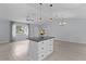 Open floor plan featuring a kitchen island, lots of light, and modern fixtures at 17965 Se 107Th Ct, Summerfield, FL 34491