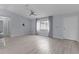 Bright living room with light gray flooring, a ceiling fan, and a large window for ample natural light at 17965 Se 107Th Ct, Summerfield, FL 34491