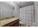 Bathroom featuring a granite vanity, toilet, and tiled shower with a patterned curtain at 1852 Rafton Rd, Apopka, FL 32703