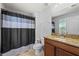 Bathroom featuring a granite vanity, toilet, and tiled shower with a black and gray curtain at 1852 Rafton Rd, Apopka, FL 32703
