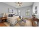 Bright bedroom with neutral tones, a ceiling fan, and stylish furnishings including a plush bed and wooden accents at 1852 Rafton Rd, Apopka, FL 32703
