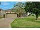 A single-Gathering home features a two-car garage, green lawn, mature trees, and a screened patio at 1852 Rafton Rd, Apopka, FL 32703
