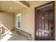 Inviting front porch with stone accents, a modern dark wooden front door and natural light at 1852 Rafton Rd, Apopka, FL 32703