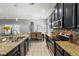 Galley kitchen featuring granite countertops, stainless steel appliances, and an open view to the dining room at 1852 Rafton Rd, Apopka, FL 32703