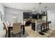 Modern kitchen features black cabinets, stainless steel appliances, and a breakfast bar, complemented by an adjacent dining area at 1852 Rafton Rd, Apopka, FL 32703