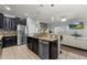 Modern kitchen with stainless steel appliances, granite countertops, and an open view to the living area at 1852 Rafton Rd, Apopka, FL 32703